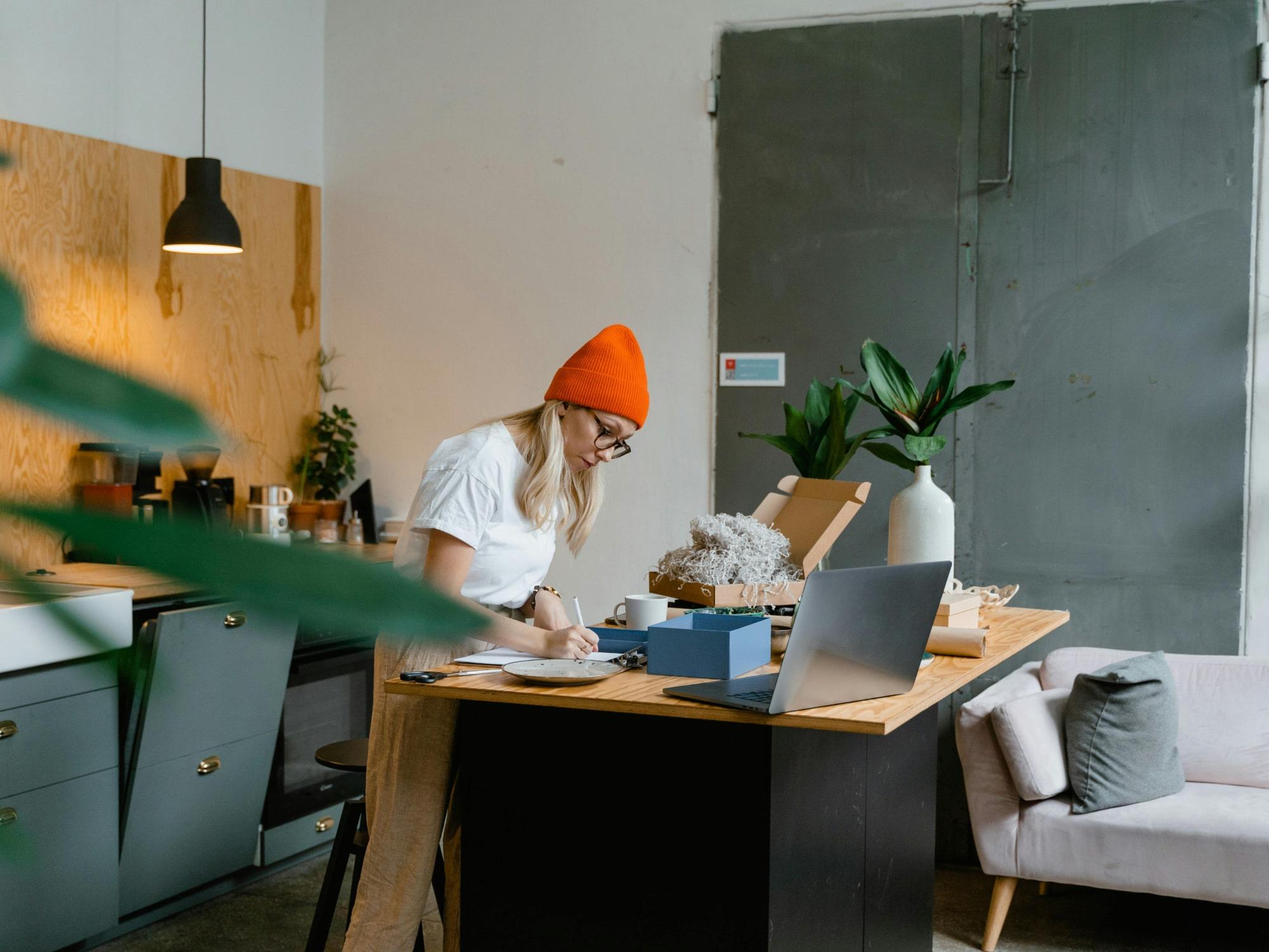 Person working at laptop with plants on desk