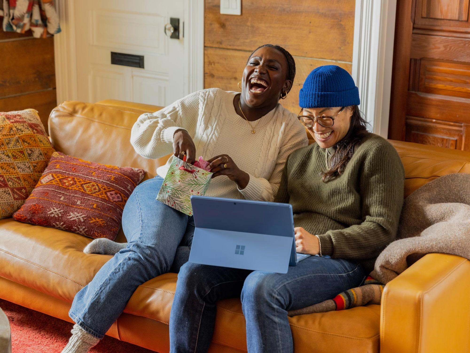 Two people with laptop on couch
