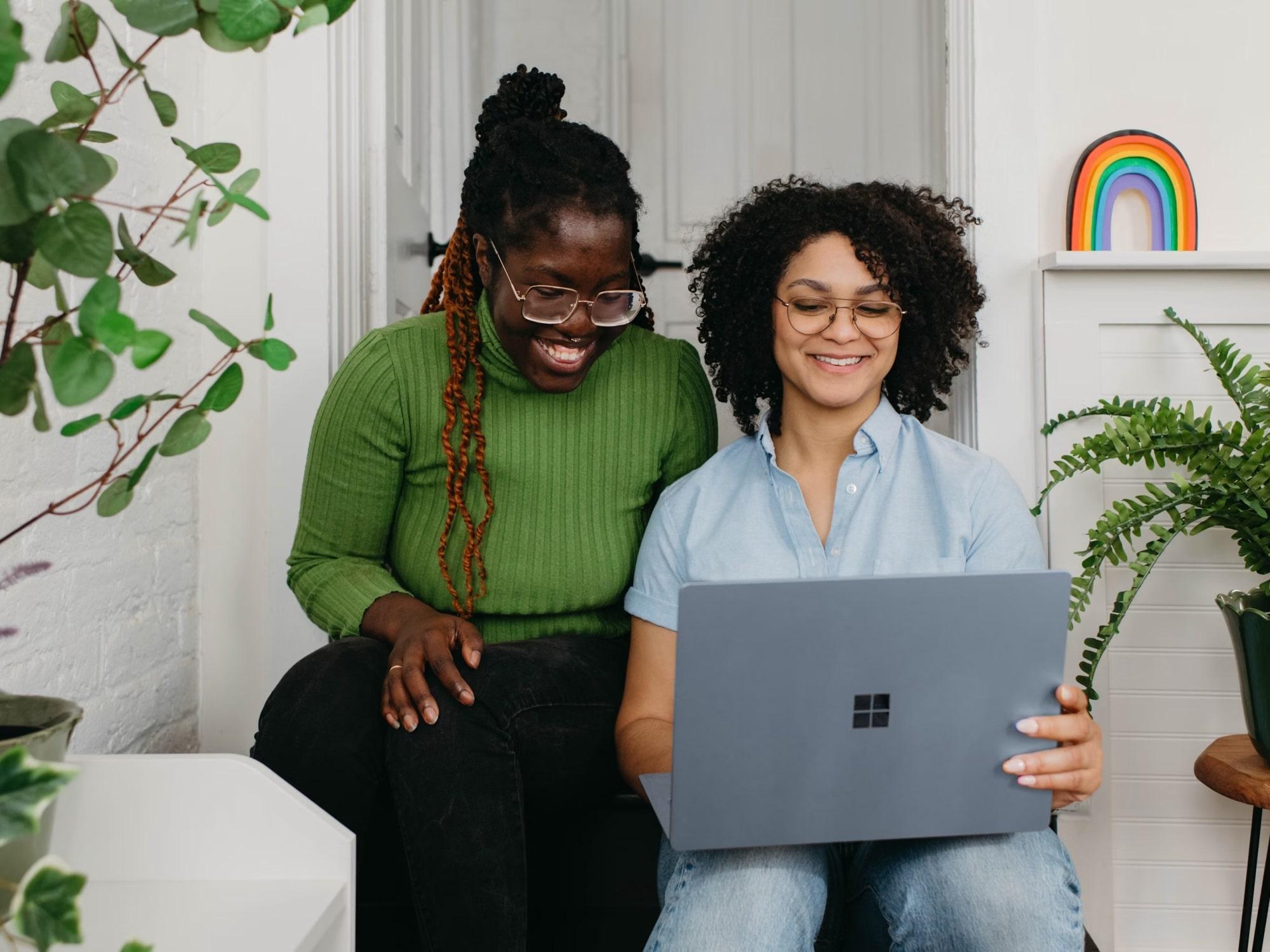 Two colleagues reviewing a laptop together